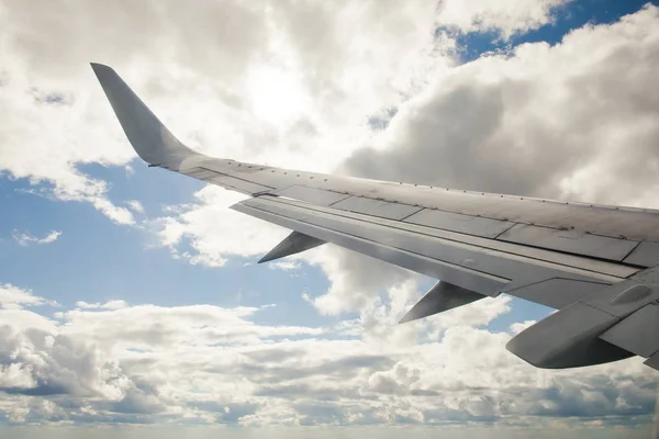 El ala del avión sobre un fondo de nubes y cielo azul . —  Fotos de Stock