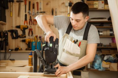 Ekipman Atölyesi'nde oyma ile çalışan adam. Chinseling oluk