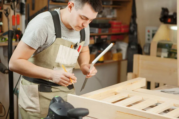 L'artisan mesure la distance entre les planches de bois à l'aide d'une règle . — Photo