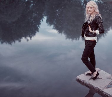 bir sarışın gölette var. siyah giysili bir kadın. Stil ve renk kombinasyonu.