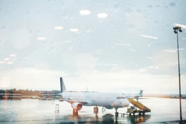 Avión recoge pasajeros en la lluvia. desventajoso de un día nublado para volar . —  Fotos de Stock