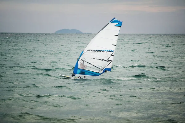 windsurfer floating on board at sea.