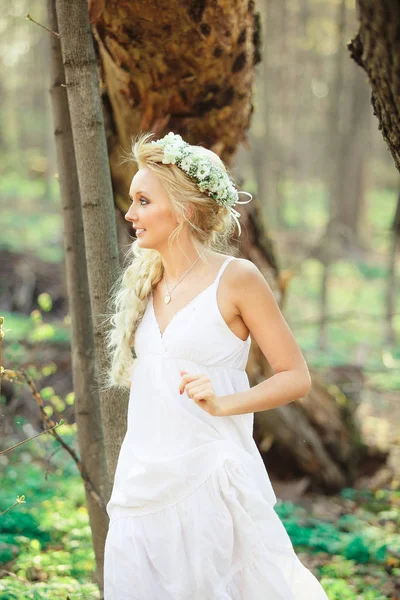 Mujer rubia vestido blanco camina en el bosque de verano . — Foto de Stock