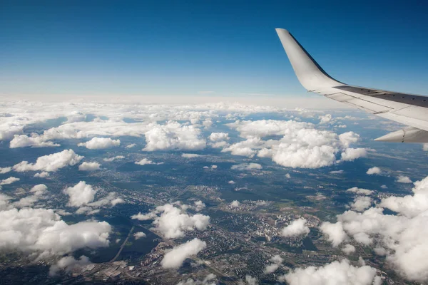 Hermosa vista desde la portilla de la ventana. ala del avión sobre un fondo de nubes y cielo azul. vuelo del avión sobre la ciudad . —  Fotos de Stock