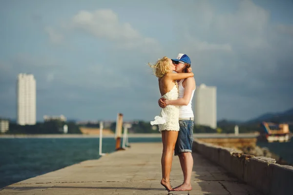 Νεαρό ζευγάρι φιλί στην αποβάθρα κατά τη θάλασσα. Μήνας του μέλιτος εραστές. — Φωτογραφία Αρχείου
