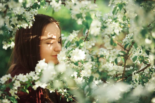 Junge Frau mit sauberer Haut in der Nähe eines blühenden Apfelbaums. Sanftes Mädchenporträt im Frühlingspark. — Stockfoto