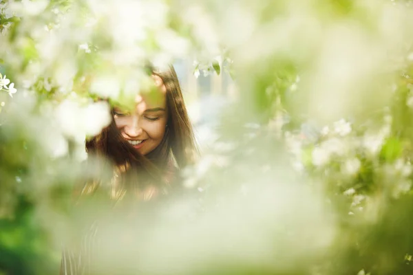 Porträt einer lächelnden und glücklichen Frau in der Nähe von Bäumen. — Stockfoto