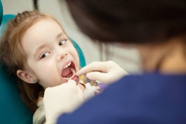 Çocuk ağız diş hekimi lastik eldiven denetler