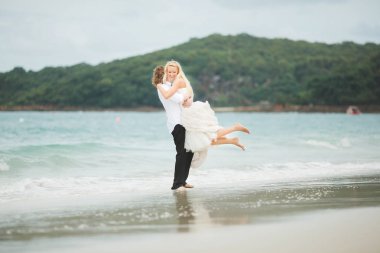 Gelin ve damat denizde sarılma. ıssız sahilde aşık Çift.