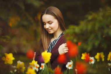 güzel kız ekili çiçeklere oturur.