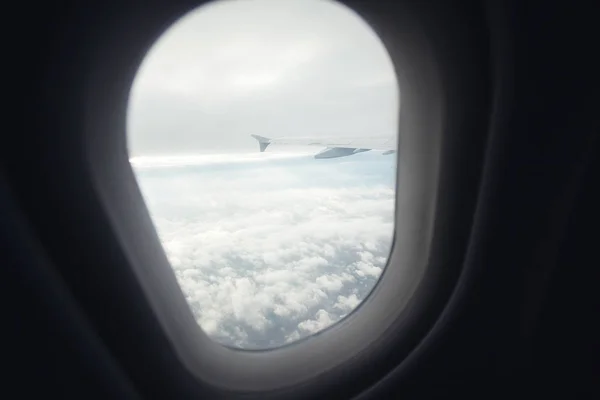 Belle vue depuis hublot fenêtre. l'aile de l'avion sur fond de nuages . — Photo