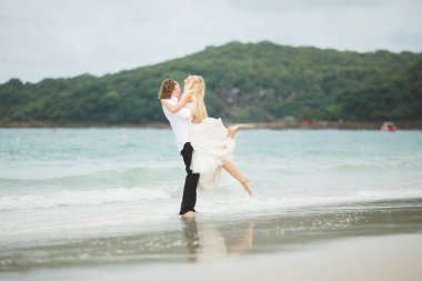 Gelin ve damat denizde sarılma. ıssız sahilde aşık Çift.