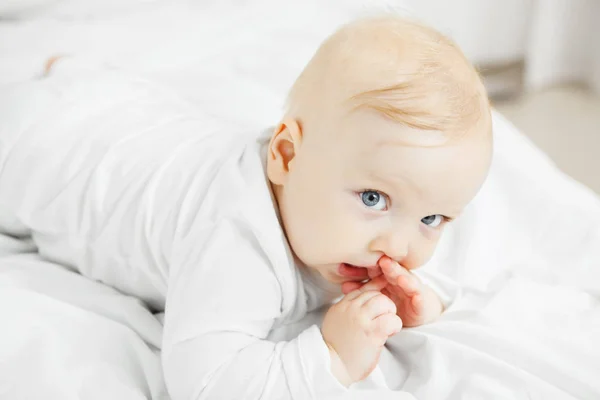 Bebê bonito está com o polegar na boca — Fotografia de Stock