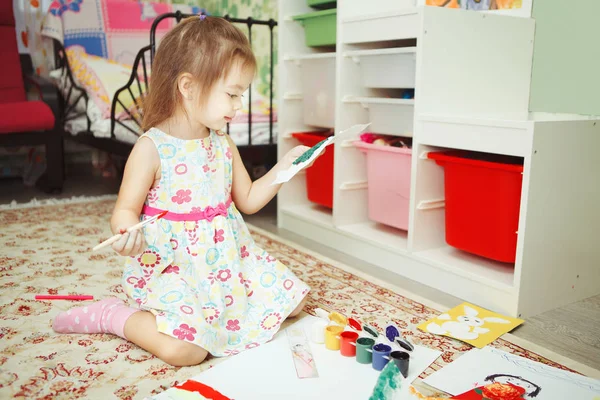 Ragazza gentilmente guardando l'immagine disegnata da lei — Foto Stock