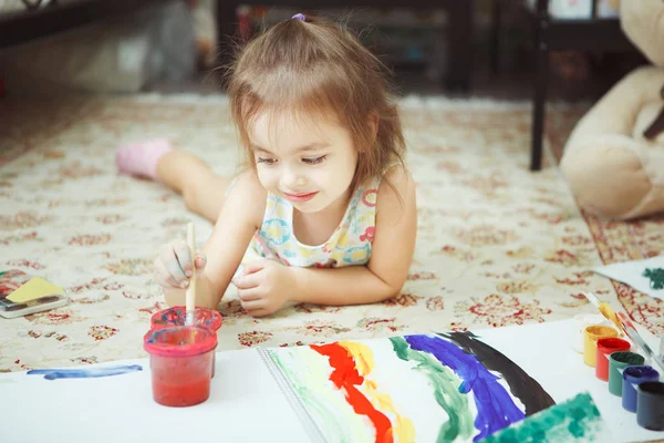 Ragazzina si trova sul pavimento della camera da letto e dipingere quadro — Foto Stock