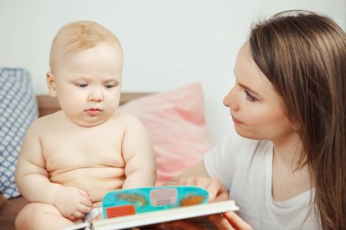 Peri masalları ile küçük bebek renkli kitap okuma anne.