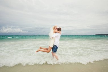 Gelin ve damat denizde sarılma. ıssız sahilde aşık Çift.