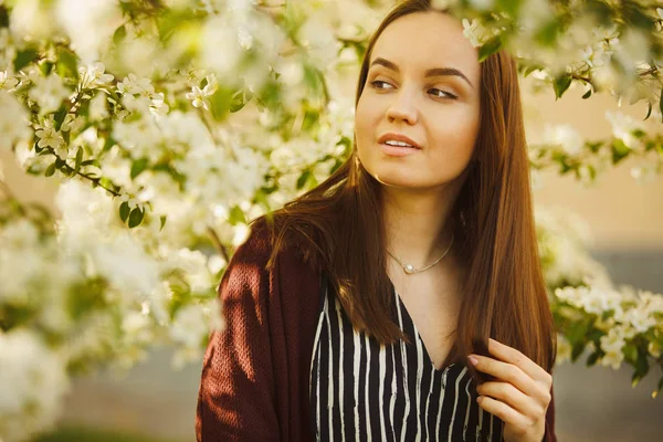 Fiatal nő a tiszta bőr közelében egy virágzó almafa. park tavaszi lány portréja. — Stock Fotó