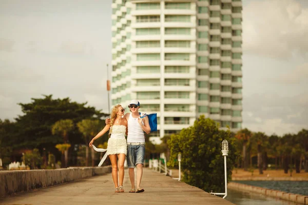 Jovem casal caminhando no cais para o mar. Lugares de lua-de-mel. férias de casais . — Fotografia de Stock