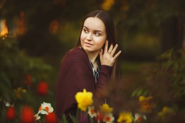 güzel kız ekili çiçeklere oturur.