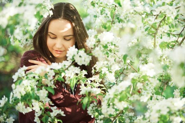 Jovem com pele limpa perto de uma macieira florescente. retrato suave de menina no parque de primavera . — Fotografia de Stock