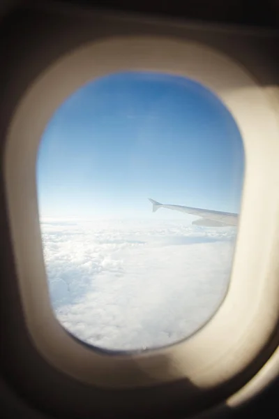 Bela vista da janela pórtico. a asa do avião em um fundo de nuvens e céu azul . — Fotografia de Stock