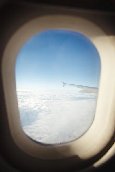 Hermosa vista desde la portilla de la ventana. el ala del avión sobre un fondo de nubes y cielo azul . —  Fotos de Stock