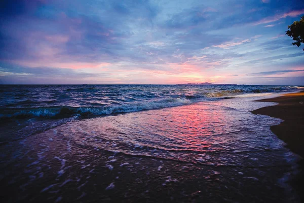 海滩上的粉红色日落。黄昏时分有波浪的海滩. — 图库照片