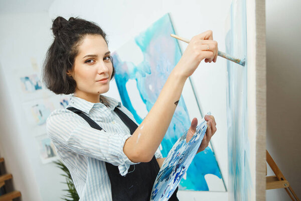 Концентрированная девушка сосредоточена на творческом процессе в арт-терапии
