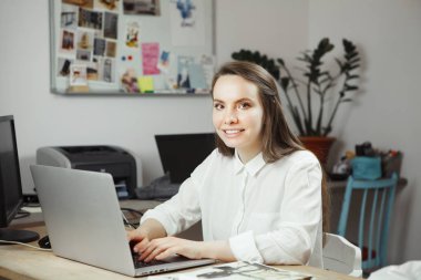 Bilgisayarda, çekici gülümseyen kadın başarılı stilisti serbest çalışma