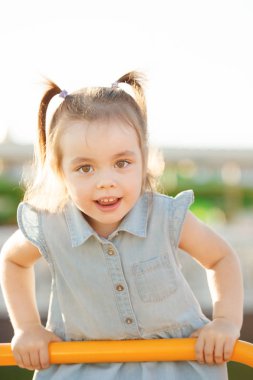 Çocuk parkta merdivenlerden tırmanıyor.