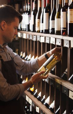 Düşünceli uzman şarap raflara arka plan üzerinde şarap yapımı.