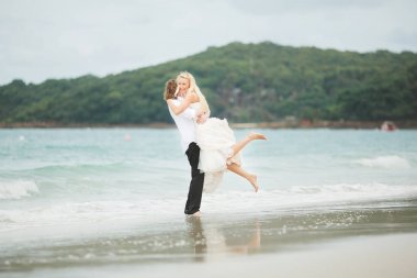 Gelin ve damat denizde sarılma. ıssız sahilde aşık Çift.