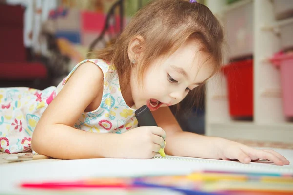 Küçük kız dikkatle çizmek resim not defterinde keçeli kalemle — Stok fotoğraf