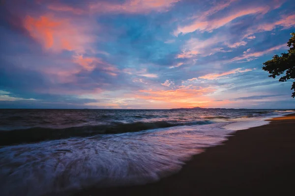 海滩上的粉红色日落。黄昏时分有波浪的海滩. — 图库照片