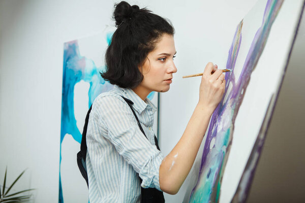 Концентрированная девушка сосредоточена на творческом процессе в арт-терапии
