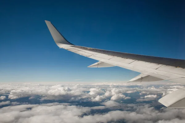 Hermosa vista desde la portilla de la ventana. el ala del avión sobre un fondo de nubes y cielo azul . —  Fotos de Stock