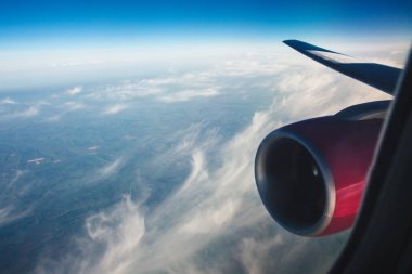 gökyüzüne karşı pembe bir motoru ile uçak kanadı. pencere Lombar tüylü bulutlar. ruh hali tatil.