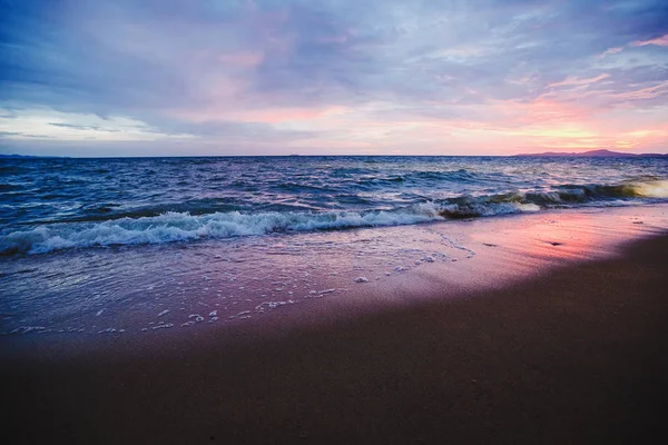 海滩上的粉红色日落。黄昏时分有波浪的海滩. — 图库照片