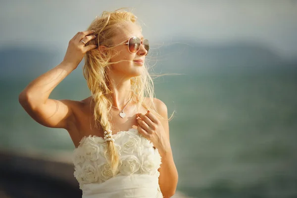 Kobieta z okulary i biały ślub sukienka na tle morza. — Zdjęcie stockowe