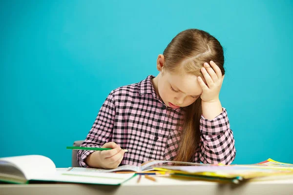 Portrét frustrovaný dívka u stolu s učebnice, vyjadřuje únavu a zklamání, položil ruku na hlavu, si lámou hlavu rozhodnutí úkolu, nic podobnýho modrá, samostatný. — Stock fotografie