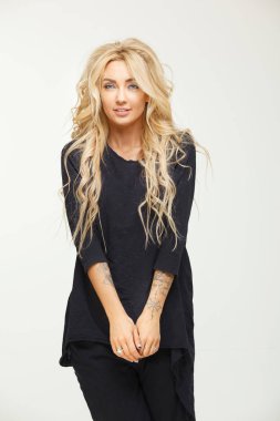 Beyaz stüdyo arka plan üzerinde siyah uzun ceketli sarışın kız.