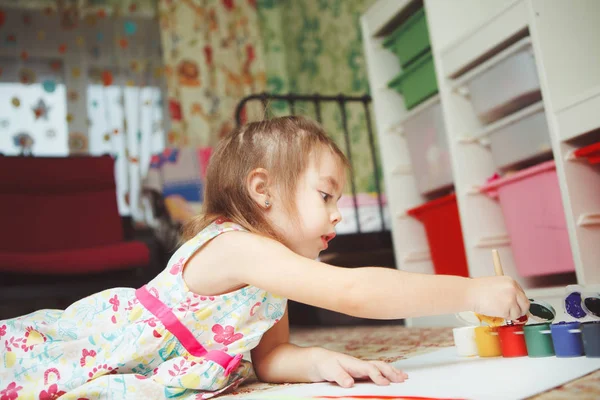 Niña se encuentra en el suelo del dormitorio y pintura cuadro — Foto de Stock