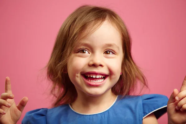 Portrait de joyeuse petite fille de bonne humeur sur fond rose isolé . — Photo