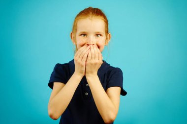 Neşeli ifade ile yaramaz kız eliyle ağzını kapatıyor, güler yüz, o söylediği için duygu vicdan vardır.