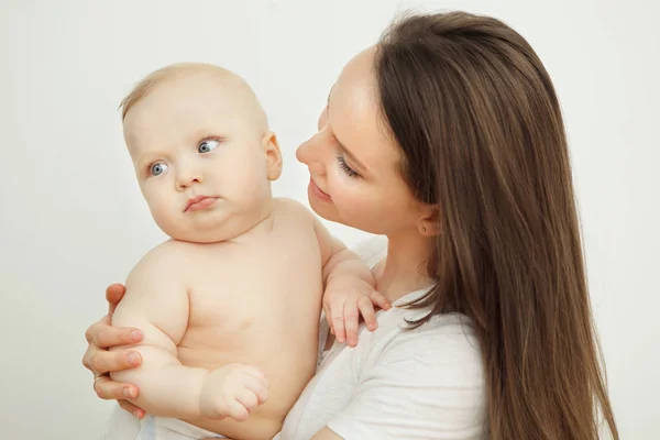Madre mira al niño con cariño, bebé en brazos — Foto de Stock