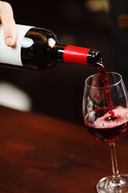 Garson şarap kadehine kırmızı şarap dolduruyor. Sommelier alkollü içecek doldurur.