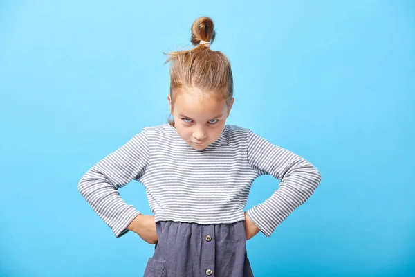 Pequeña niña enojada de pie sobre fondo blanco, signo y concepto de gesto . —  Fotos de Stock