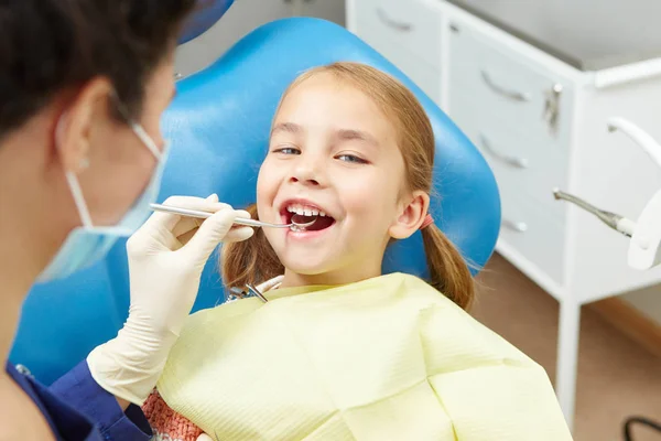 Uma menina sentada no consultório dos dentistas. Odontologia pediátrica . — Fotografia de Stock