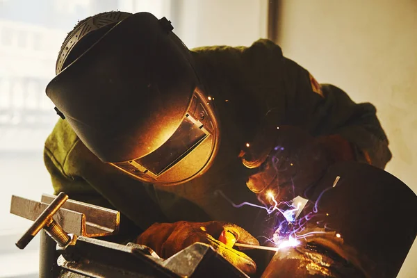 Trabalhador em máscara de segurança solda metal em empresas industriais . — Fotografia de Stock